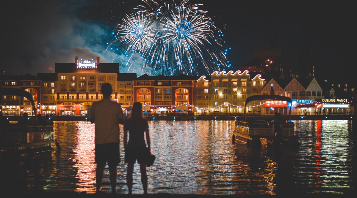a photo of two people celebrating new year watching firewalks beside a body of water