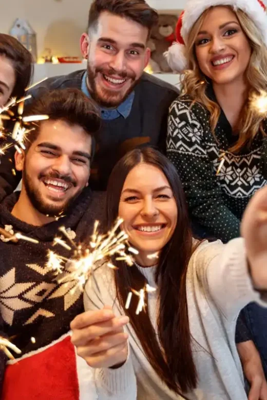 Cheerful group of people with sparkles together celebrating New Year eve