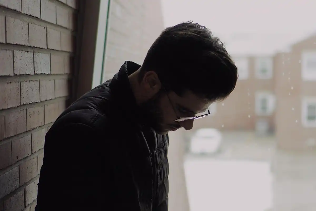 young man feeling lonely during rainy season suffering from seasonal affective disorder