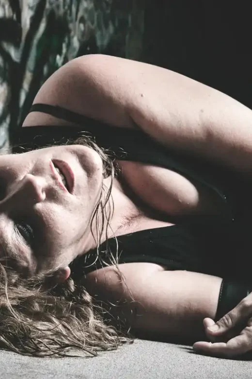 A woman lay into the ground having drug in vain in a dark place