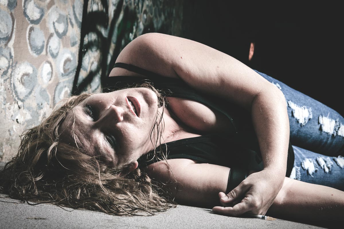 A woman lay into the ground having drug in vain in a dark place