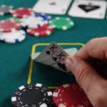 photo of a man's hand holding playing cards at the casino