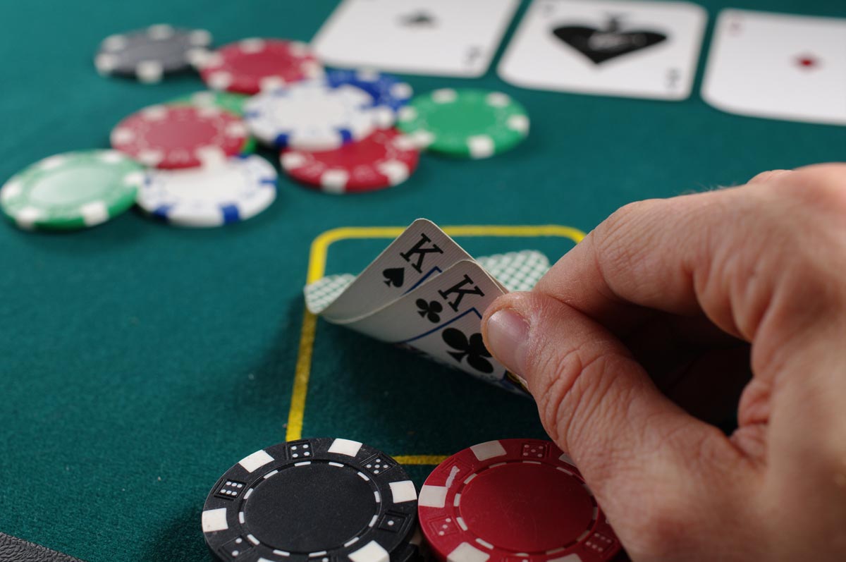 photo of a man's hand holding playing cards at the casino