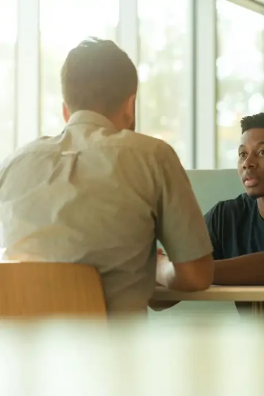 photo of two men talking in the cafeteria Improving Communication Skills