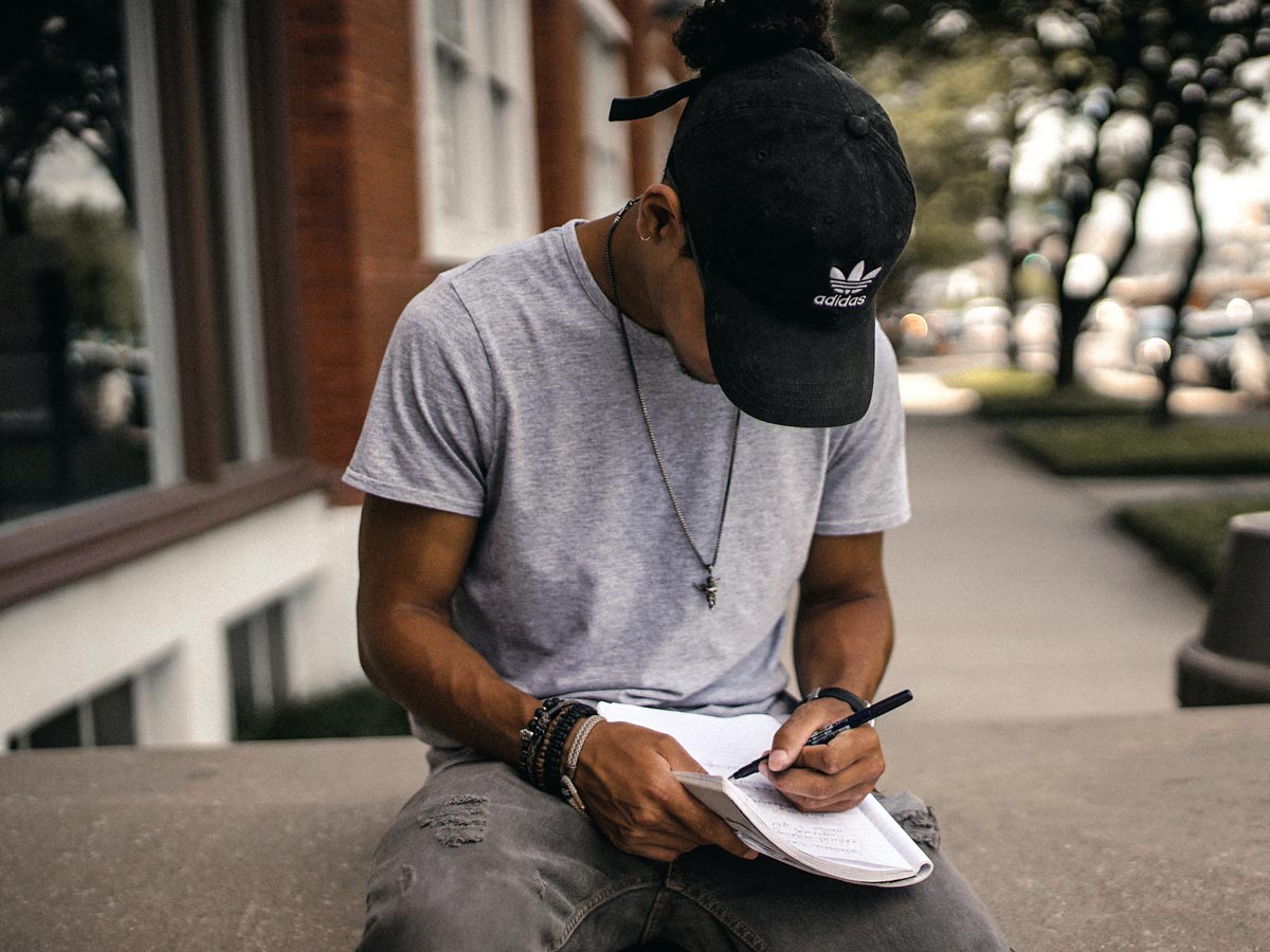man writing in a gratitude journal