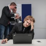 photo of an employee having strong headache tired from laptop work