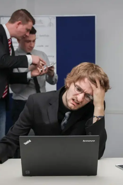 photo of an employee having strong headache tired from laptop work