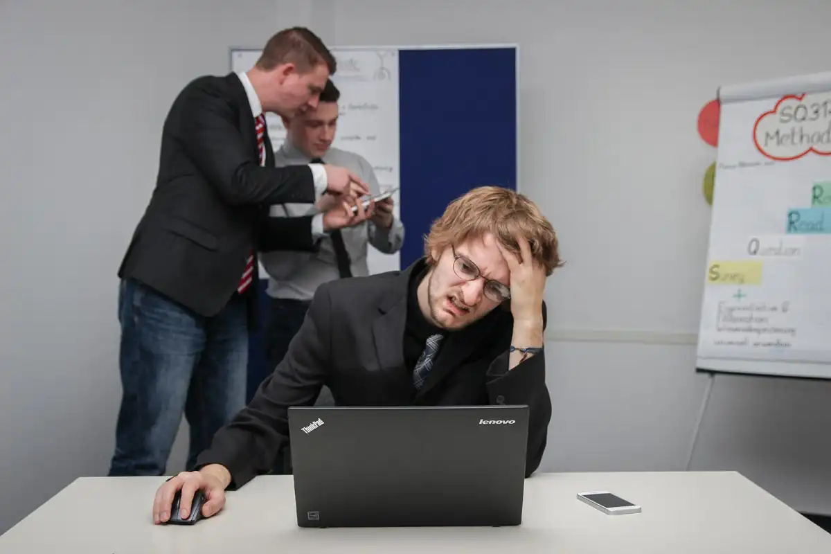 photo of an employee having strong headache tired from laptop work