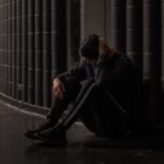 photo of a depressed man sitting on the floor