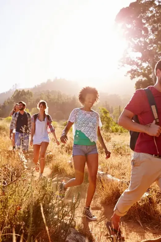 Group Of Alumni On Walk Through Countryside Together