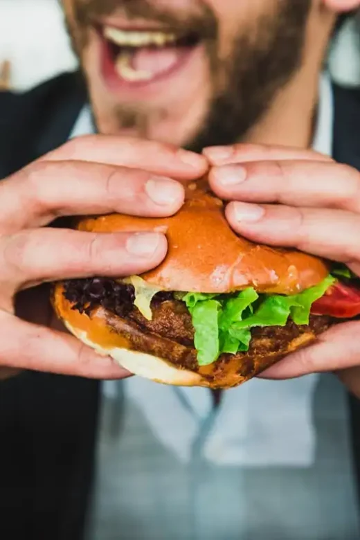 a photo of a man with eating disorder eating hamburger and fries
