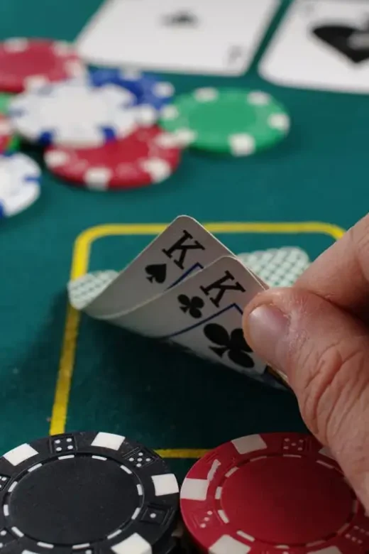 photo of a man's hand holding playing cards at the casino