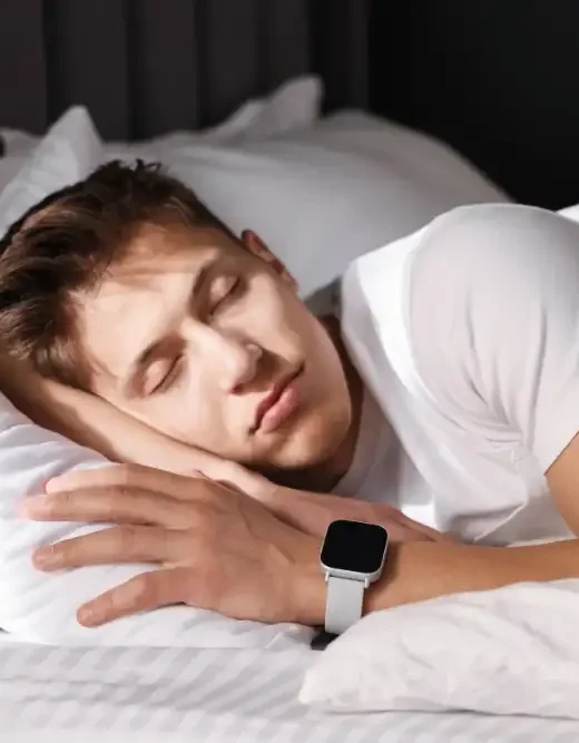 Young Man with Sleep Tracker Sleeping on Bed at Home