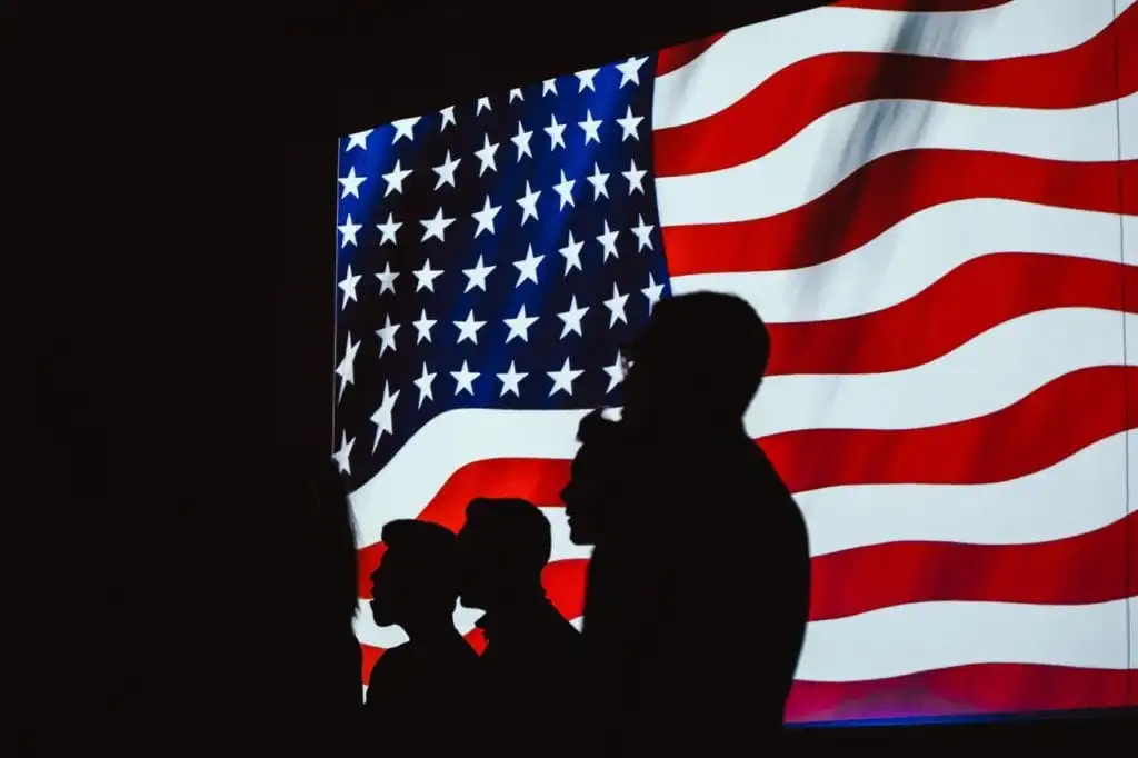 american flag in the background of silhouette of people