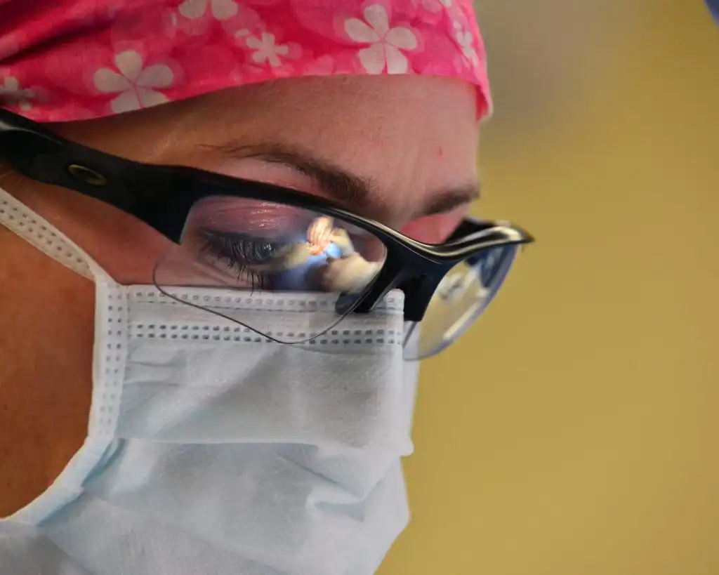 Young medical professional wearing a mask and surgical glasses prescribing opioid medications