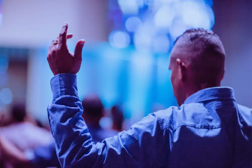 a recovering addict man inside a church wearing blue polo