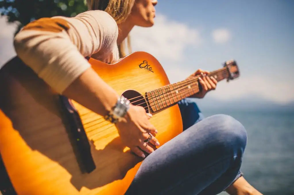 Woman playing guitar by the beach in southern California
