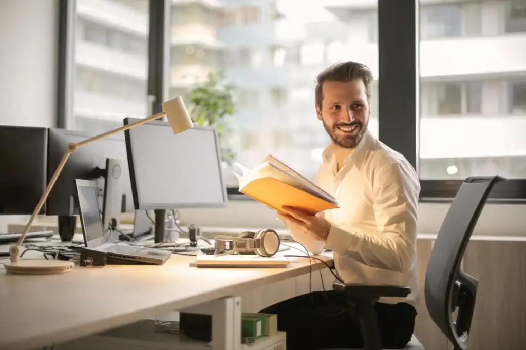 Man in an office who is exceptionally happy to finally be sober and fully recovered from his addiction to drugs and alcohol