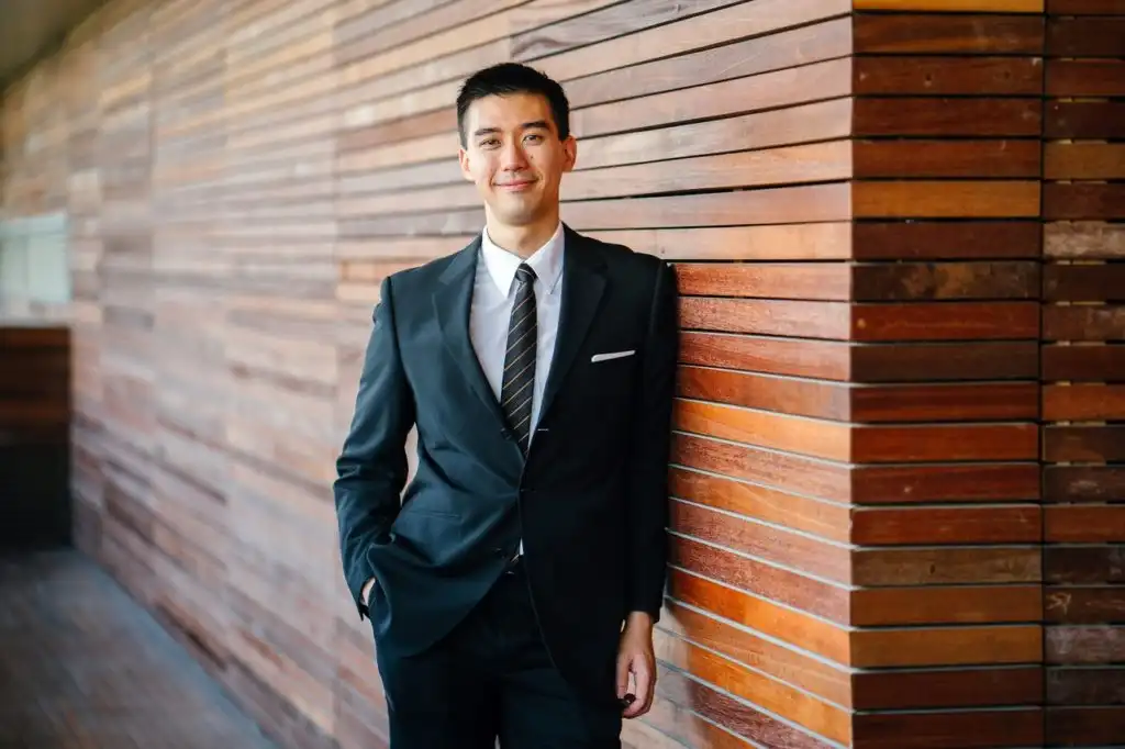 Young professional in a business suit standing near their workplace that helped with their substance use disorder