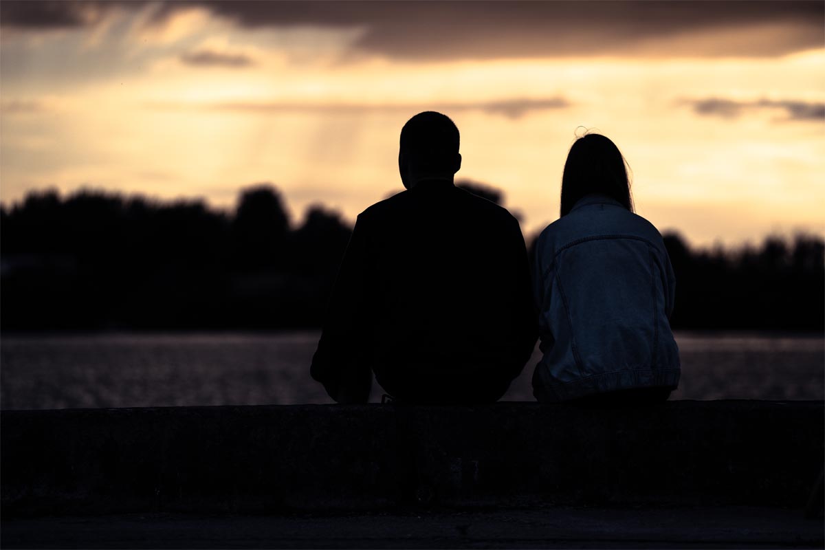 a couple having deep conversation during sunset