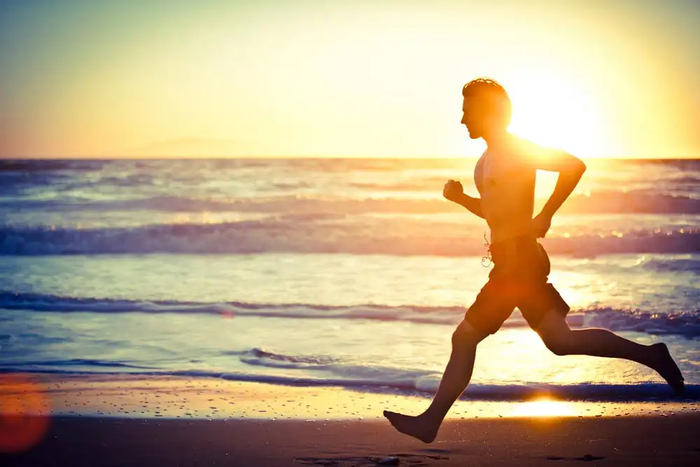 a barefoot man running by the sea on the beach 7 Tips If You’re New to Rehab