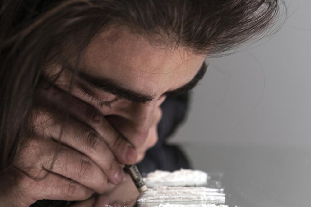 10-Acre-Ranch-treatment-photo-of-a-Man snorting cocaine on mirror table