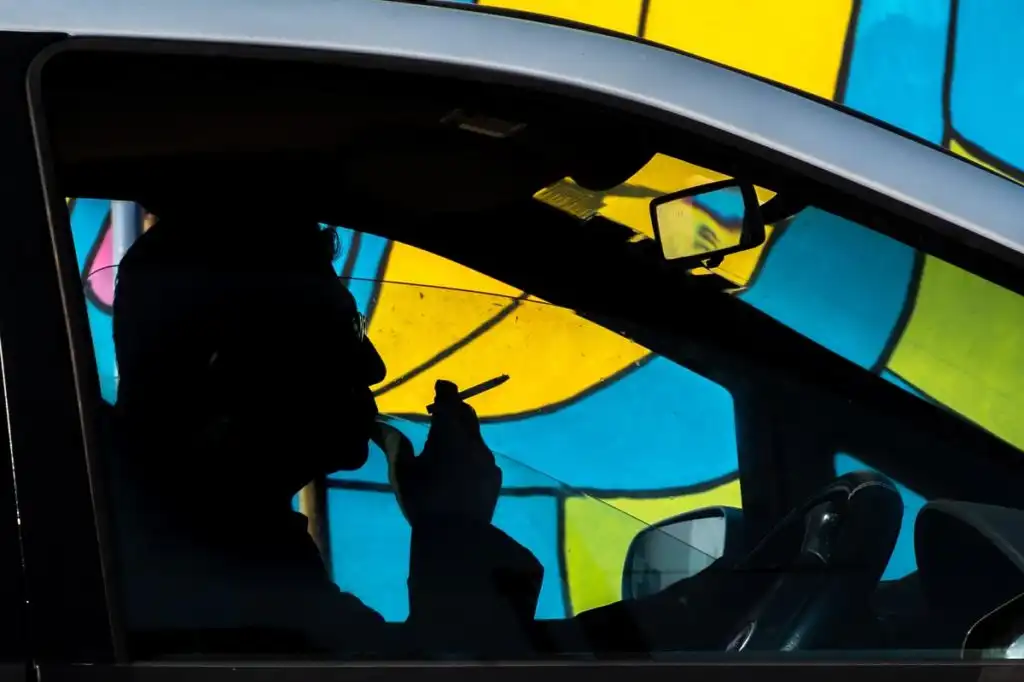 a man smoking marijuana while driving a car