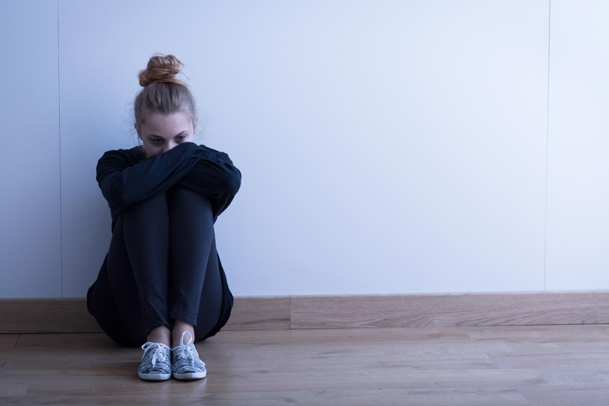 Photo of Sad woman with depression sitting on the floor
