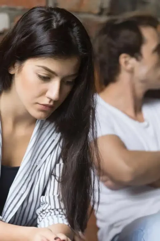 a sad young woman thinking of relationships problems sitting on sofa with offended husband