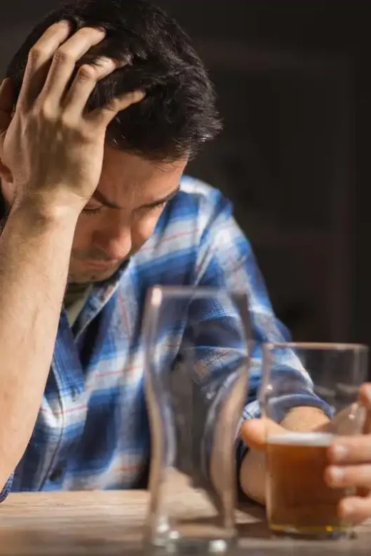 a male alcoholic drinking beer from glass at night alcohol addiction