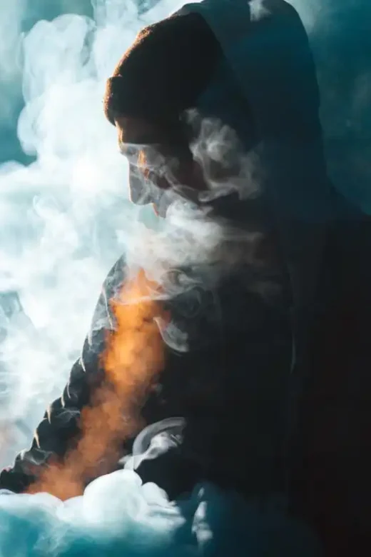 a man wearing hoodie vaping drug addiction concept