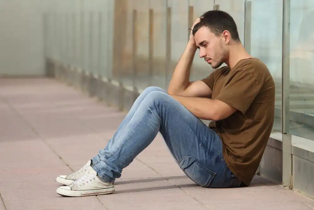 a thoughtful man sitting in a corner