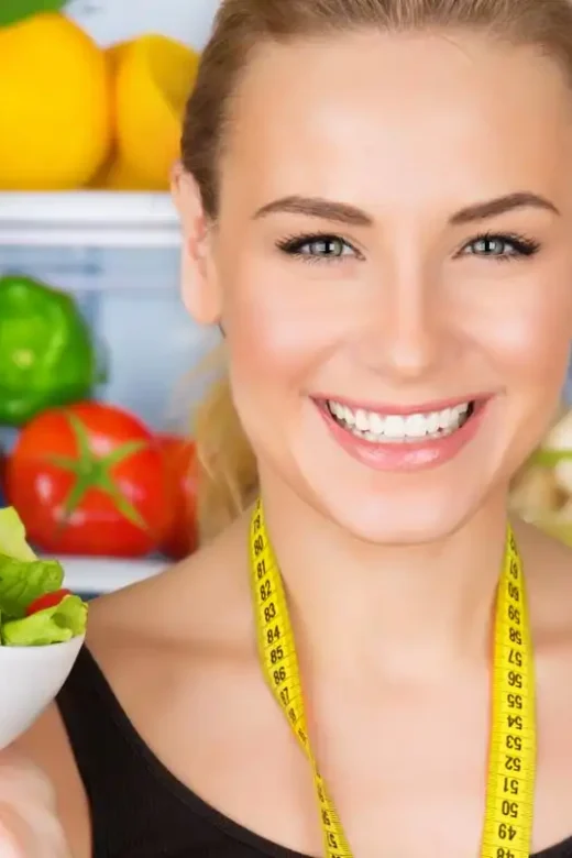 a woman holding a bowl of vegetables, considering healthy nutrition to support her recovery
