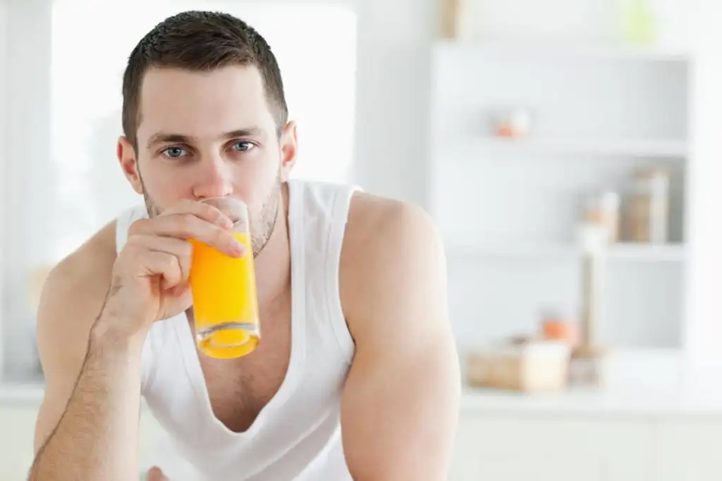 a young man drinking fruit shake