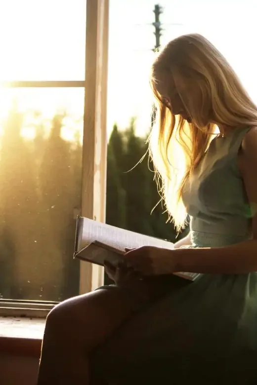 a beautiful woman reading inspirational quotes from a book