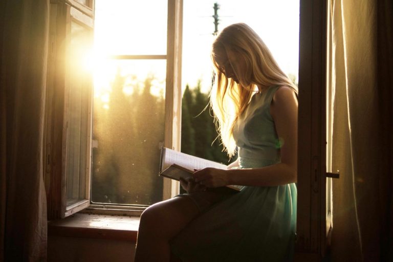 photo of a beautiful woman reading inspirational quotes from a book