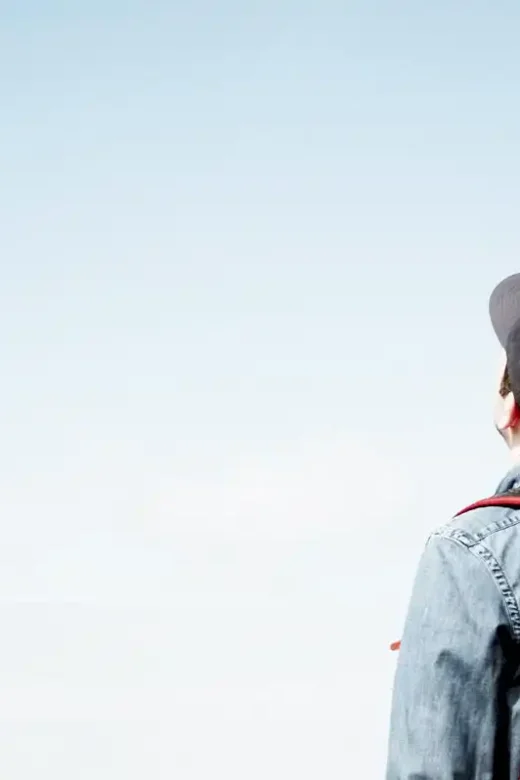 young college man wearing red back pack looking up the sky