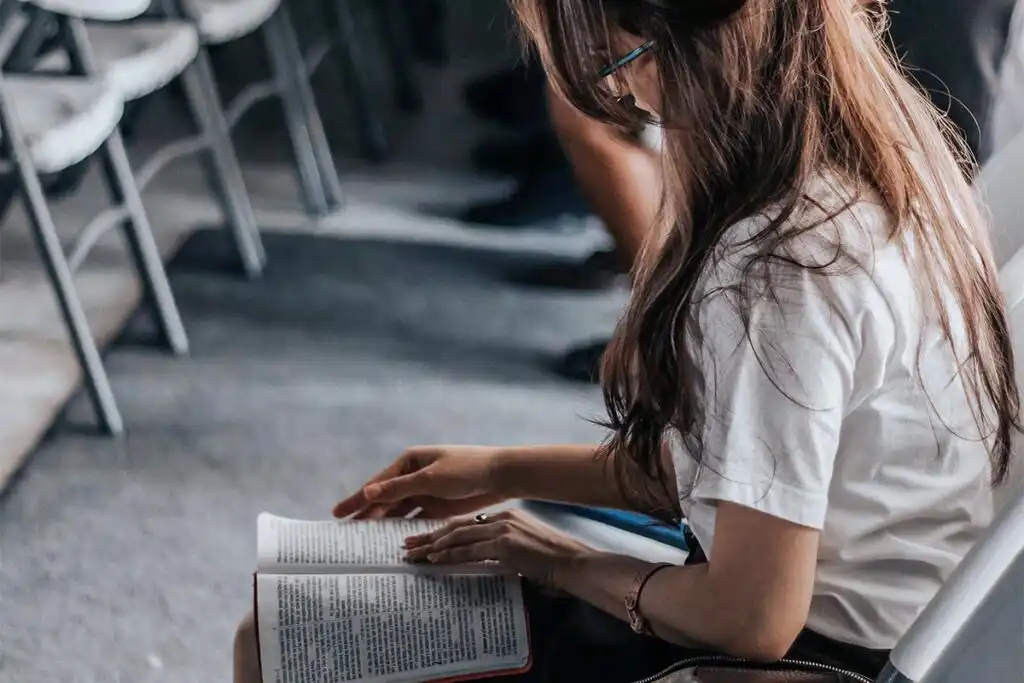 woman reading bible during praying meeting