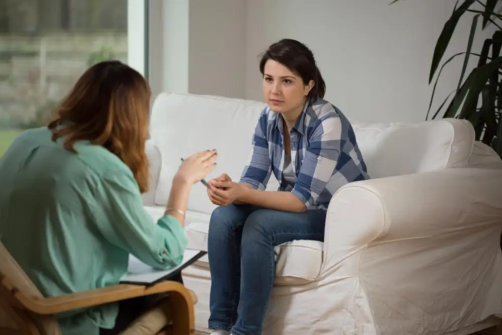 Young stressed woman listening psychologist analysis