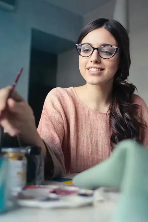 a happy young woman found a new hobby painting addiction treatment center in Riverside California