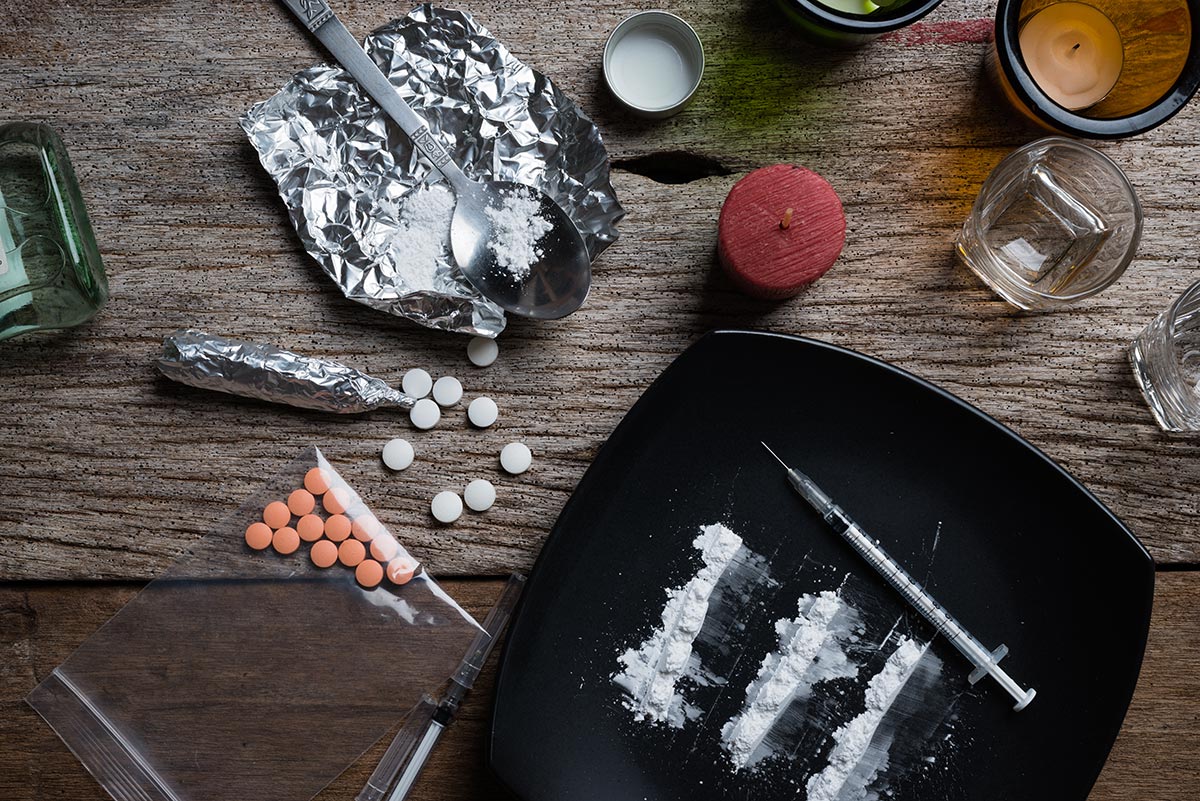 alcohol, drugs, pills on a wooden background