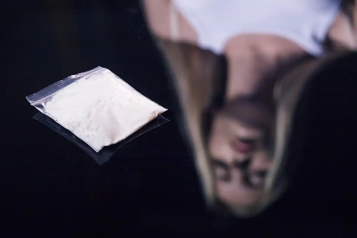 female looking at the cocaine cut in the table