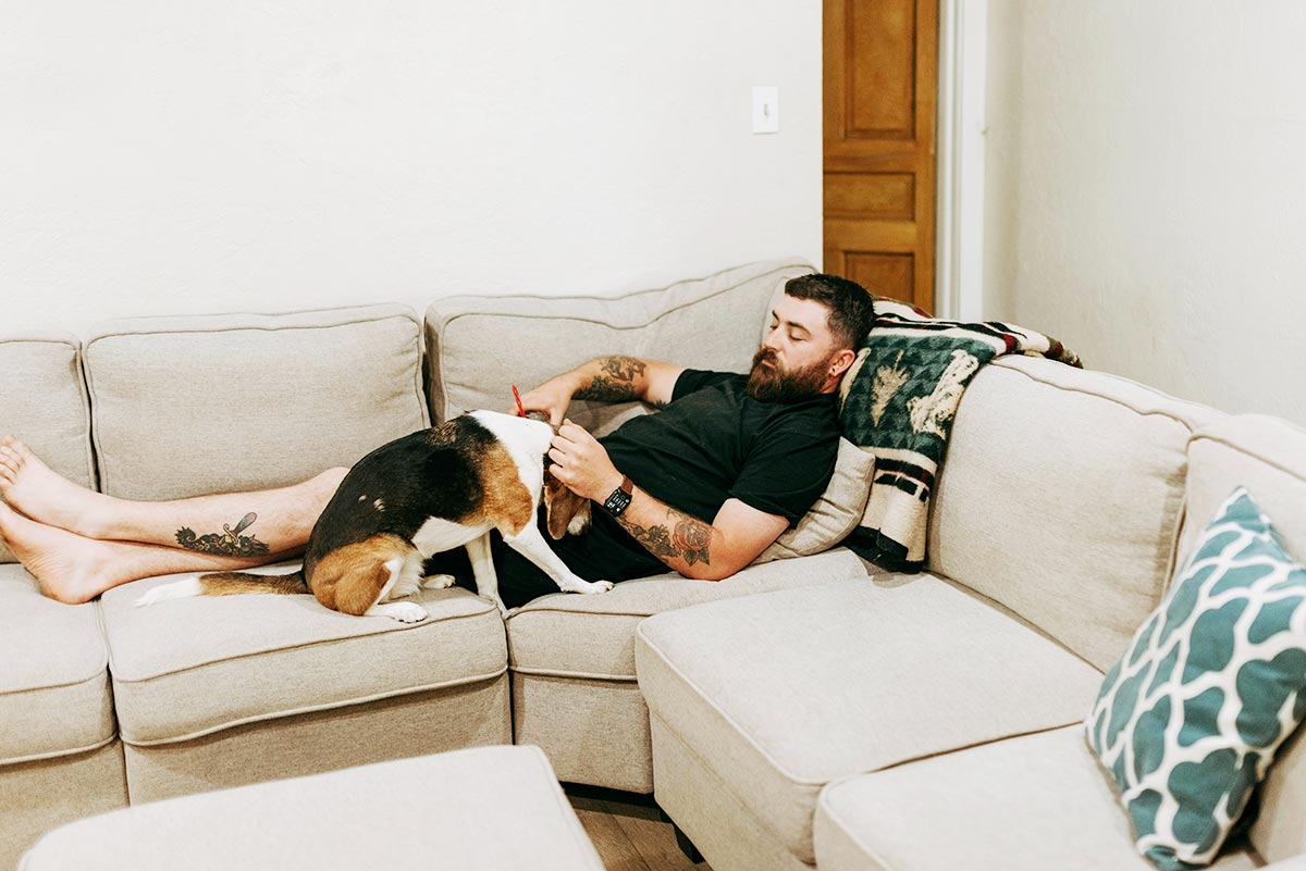 a male client lying on the sofa with his pet at a drug and rehab treatment center in riverside ca