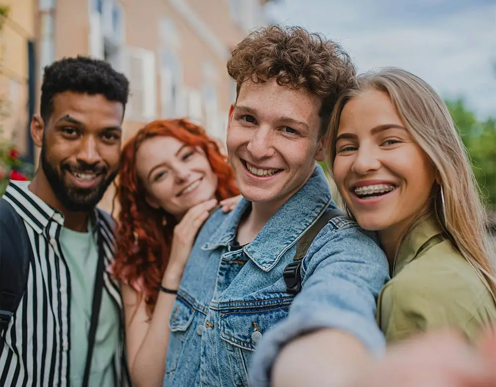 4 young adults smiling for the camera at a young adult drug rehab center