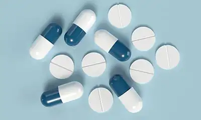 A blue and white pills set on a blue surface, illustrating stimulants