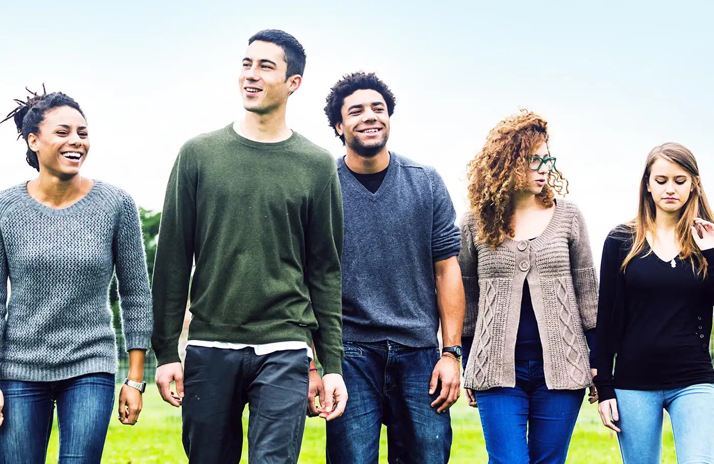 A diverse group of young adults walking in a field, embodying the spirit of recovery from cocaine addiction in California.