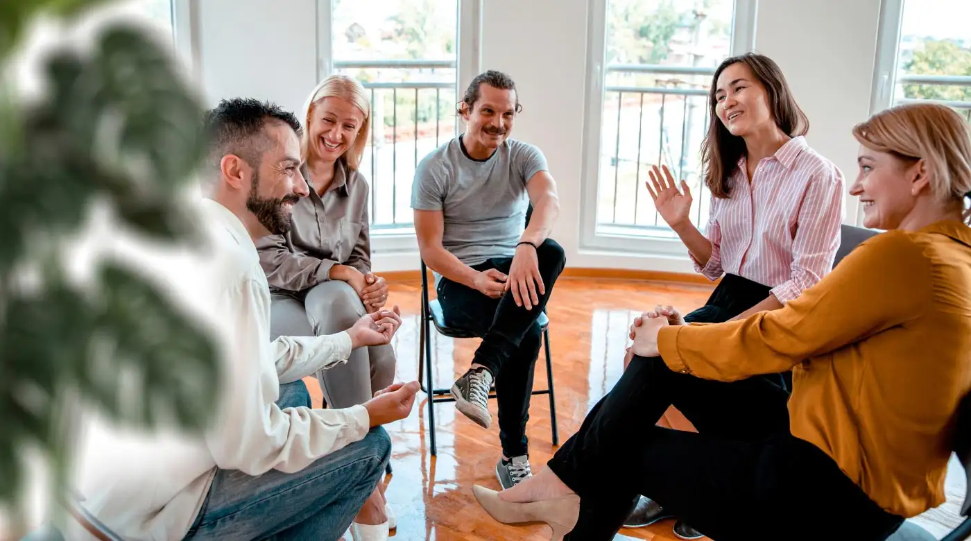 A group of individuals engaged in discussion around a table during fentanyl addiction treatment