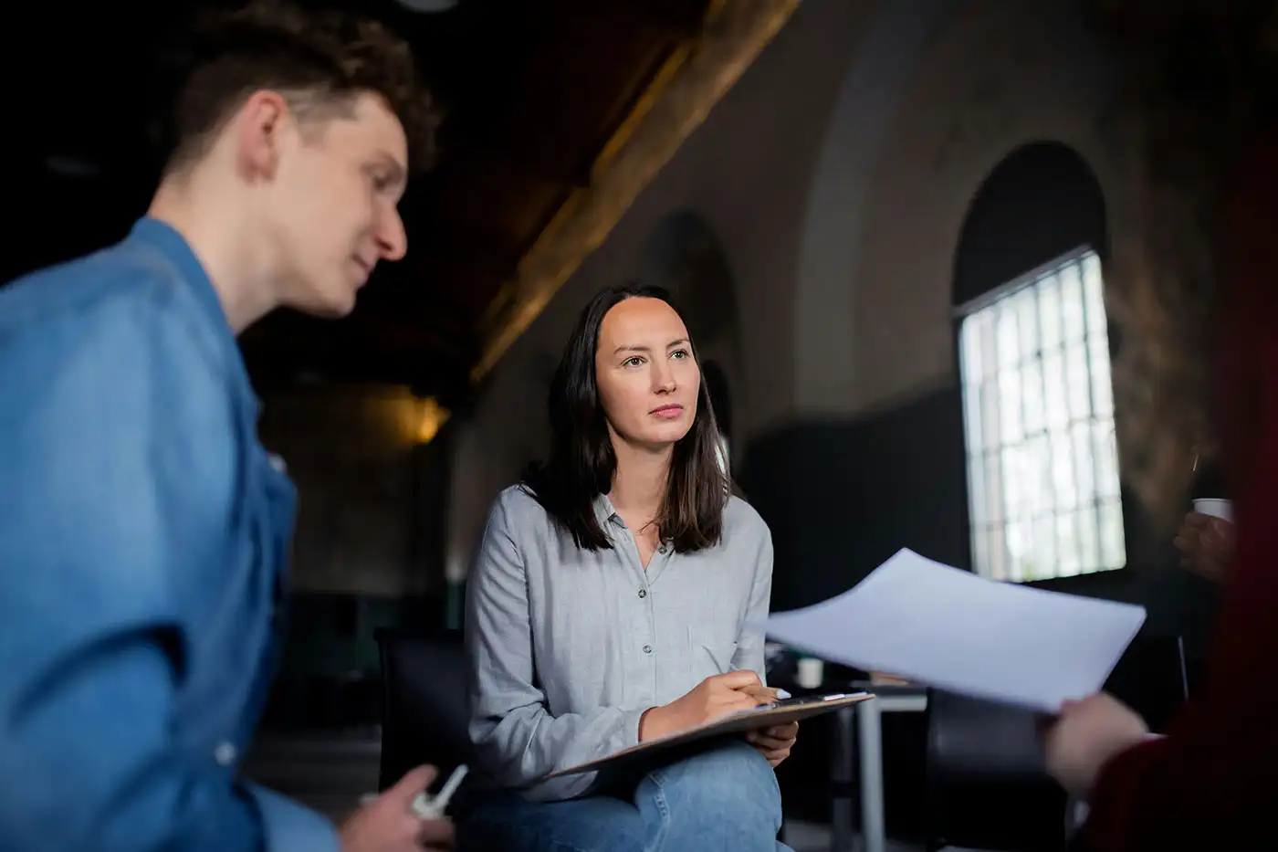 A man and woman engage in discussion in a meeting room during inpatient bipolar treatment.