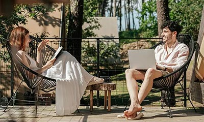 A man and woman seated on chairs outdoor during a drug detox program in a supportive environment.