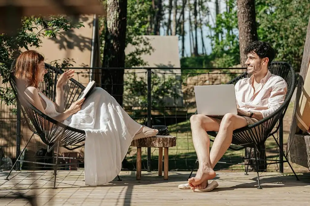 A man and woman seated on chairs outdoor during a drug detox program in a supportive environment.